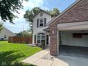 Exterior shot of a home with a brick two-car garage and a well-maintained lawn and partial view of the home at 563 Jet Stream Blvd, Westfield, IN 46074
