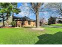Brick home with green lawn and a mature tree in the yard on a sunny day at 601 Ridge Rd, Greenwood, IN 46142