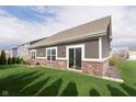 Backyard view highlighting the well-maintained lawn and the home's siding and brickwork at 6156 N Cedarwood Dr, McCordsville, IN 46055