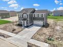 A three-quarter view of the two-story home with gray siding, an attached garage, and a concrete driveway at 7167 Finley Creek Dr, Whitestown, IN 46075