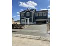 A two-story home with a dark exterior, shuttered windows and a concrete driveway under a partly cloudy sky at 7167 Finley Creek Dr, Whitestown, IN 46075