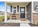 Inviting front porch featuring a black front door, brick accents, and space for decor at 8546 Strabet Dr, Pendleton, IN 46064