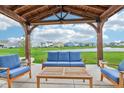 Covered patio with comfortable blue seating overlooks a pond at 8663 Kellner St, Pendleton, IN 46064