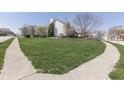 Landscaped front lawn of a beautiful brick home with sidewalk access in a residential neighborhood at 9760 Logan Ln, Fishers, IN 46037