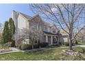 Two-story brick home with a charming front porch and American flag, surrounded by green lawns at 9760 Logan Ln, Fishers, IN 46037