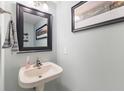Cozy powder room features a pedestal sink, framed mirror, and tasteful decor at 1014 Sugar Maple Dr, Greenwood, IN 46143