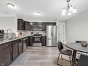 Eat-in kitchen features stainless steel appliances, dark wood cabinets, granite counters, and hardwood floors at 10844 Tedder Lake Dr, Indianapolis, IN 46239
