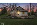 Charming home with stone chimney and landscaped front yard during dusk at 1234 E 71St St, Indianapolis, IN 46220