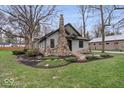 Charming home with stone chimney and landscaped front yard at 1234 E 71St St, Indianapolis, IN 46220