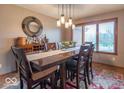 Inviting dining room with modern chandelier, wooden table with seating for six, and ample natural light at 130 George Ct, Danville, IN 46122
