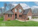 Lovely two-story brick home with attached two-car garage, lush lawn, and mature trees at 130 George Ct, Danville, IN 46122