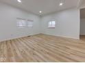 A bright bedroom with hardwood floors, three windows, and white walls at 1360 N Dearborn St, Indianapolis, IN 46201