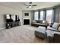 Spacious living room with a fireplace, plush carpeting, large windows, and comfortable seating providing an inviting atmosphere at 1380 Delacorte Cir, Shelbyville, IN 46176