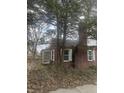 Charming single-story brick home featuring white shutters and mature trees surrounding the property at 1701 Broad Ripple Ave, Indianapolis, IN 46220