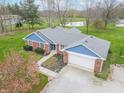 Aerial view of a brick home with a large yard, nearby pond, and mature trees at 1737 W 200 N, Greenfield, IN 46140