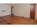 Empty living room featuring light walls and hardwood flooring throughout at 2302 W 61St St, Indianapolis, IN 46228