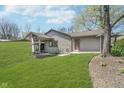 Expansive backyard showcasing lush green grass, hillside, and exterior of the home at 2305 Van Ness Pl, Indianapolis, IN 46240