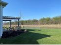 Picturesque backyard with a pergola, view of a pond, and a well-maintained lawn, creating a peaceful oasis at 2755 Ruffian Dr, Westfield, IN 46074