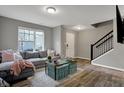 Cozy living room with grey sofa, wood floors, and a staircase, creating a welcoming atmosphere at 3123 Bolton Square Blvd, Indianapolis, IN 46222