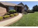 Charming brick home entrance with a curved walkway and beautifully landscaped garden beds at 415 N Westview Dr, Columbus, IN 47201