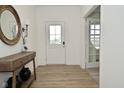 Bright entryway with a console table, round mirror and wood-look floors at 5181 Golden Grove Dr, McCordsville, IN 46055
