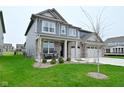 Charming two-story home boasts a three-car garage and a covered front porch at 5181 Golden Grove Dr, McCordsville, IN 46055