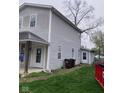Exterior shot showing side of home with gray siding, yard, and access to the back at 601 E Thompson St, Edinburgh, IN 46124