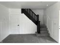 Newly carpeted staircase features modern railing and classic paneling that adds visual interest and style at 608 N Gray St, Indianapolis, IN 46201