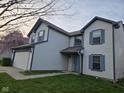 Angled view of a two-story home featuring a two-car garage, blue shutters, and a well-kept lawn at 6120 Salanie Pl, Indianapolis, IN 46254