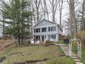 Charming two-story light blue lake house with a well-maintained lawn and a wooden walkway and staircases at 6599 Meadowlark Dr, Nineveh, IN 46164