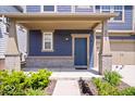 Inviting front porch with brick accents, a stylish blue front door, and lush landscaping at 7012 Pickett Pl, Carmel, IN 46033
