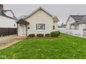 Inviting single-story home with a green lawn and classic white picket fence at 709 S A St, Elwood, IN 46036