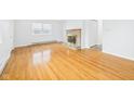 Sunlit living room featuring hardwood floors and a cozy brick fireplace at 709 S A St, Elwood, IN 46036