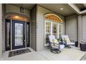 Inviting front porch featuring a decorative glass door and seating area with comfortable chairs at 749 Meadowbrook Ln, Franklin, IN 46131