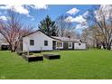 Expansive backyard featuring a lush green lawn, mature trees, and raised garden beds for gardening enthusiasts at 7859 Jennifer Ln, Brownsburg, IN 46112