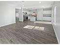 Bright, open-concept living space showcasing hardwood-style flooring and a well-lit, modern kitchen at 8251 Garden Ridge Rd, Indianapolis, IN 46237