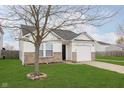 Charming single-story home with an attached garage, surrounded by lush green grass and a decorative tree border at 8529 Sansa St, Camby, IN 46113