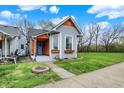 Inviting home featuring blue door, gray siding, green lawn, and lovely window boxes at 922 Cottage Ave, Indianapolis, IN 46203