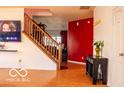 Bright entry foyer featuring hardwood floors, staircase, and decorative red wall at 10105 Yosemite Ln, Indianapolis, IN 46234