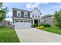 Two story home with a two car garage, gray siding, and well-maintained landscaping at 10319 Pronghorn Ln, Indianapolis, IN 46239