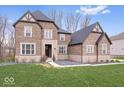 Beautiful brick two-story home with a well-manicured lawn and a professionally landscaped front yard at 16193 Burnt Rock Ln, Fortville, IN 46040