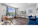 Bright living room showcasing stylish decor, large window, hardwood floors, blue velvet chairs, and modern furniture at 16193 Burnt Rock Ln, Fortville, IN 46040