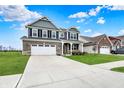 Beautiful two-story home with a well-kept lawn, a wide driveway, and charming architectural details at 1691 Beyers St, Fortville, IN 46040
