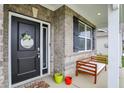 Inviting front porch with a welcome sign, a decorative bench, and colorful potted plants at 1691 Beyers St, Fortville, IN 46040
