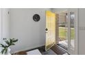 Inviting foyer featuring slate flooring, a yellow front door, and modern decor at 1708 Fox Hill Dr, Indianapolis, IN 46228