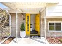 Welcoming front entrance features a bright yellow door and a modern stone facade at 1708 Fox Hill Dr, Indianapolis, IN 46228
