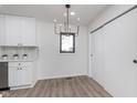 Bright dining area with modern chandelier, window, and light wood-look floors at 18037 Promise Rd, Noblesville, IN 46060