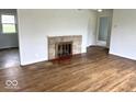 Bright living room featuring a decorative fireplace and gleaming hardwood floors at 2120 Sheffield Ave, Anderson, IN 46011