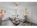 Comfortable living area boasting a large sectional sofa, ceiling fan, and updated flooring at 2221 Groff Ave, Indianapolis, IN 46222