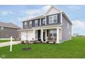 Attractive blue two-story home with a covered porch, stone accents, and a lush green lawn at 2538 Redding Dr, Whitestown, IN 46075